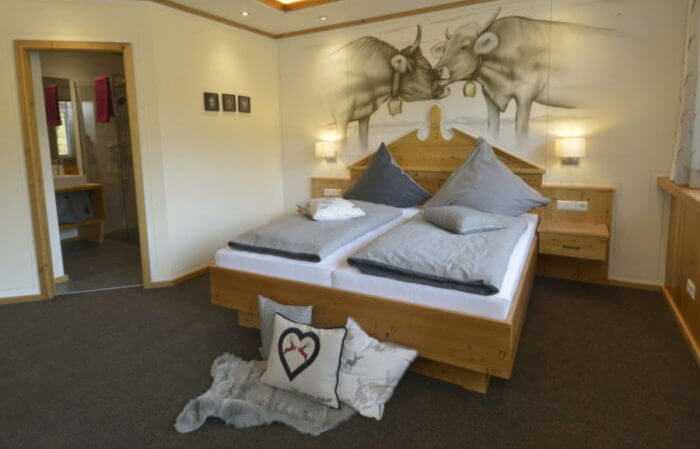 Bett aus Holz mit Kuhabbildungen an der Wand