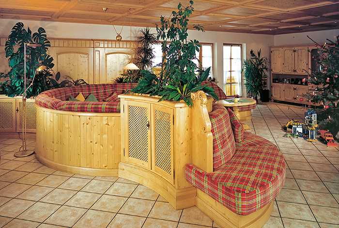 Traditionelle, rustikale Sitzbank mit karierter Polsterung in einem Raum mit Fliesenboden